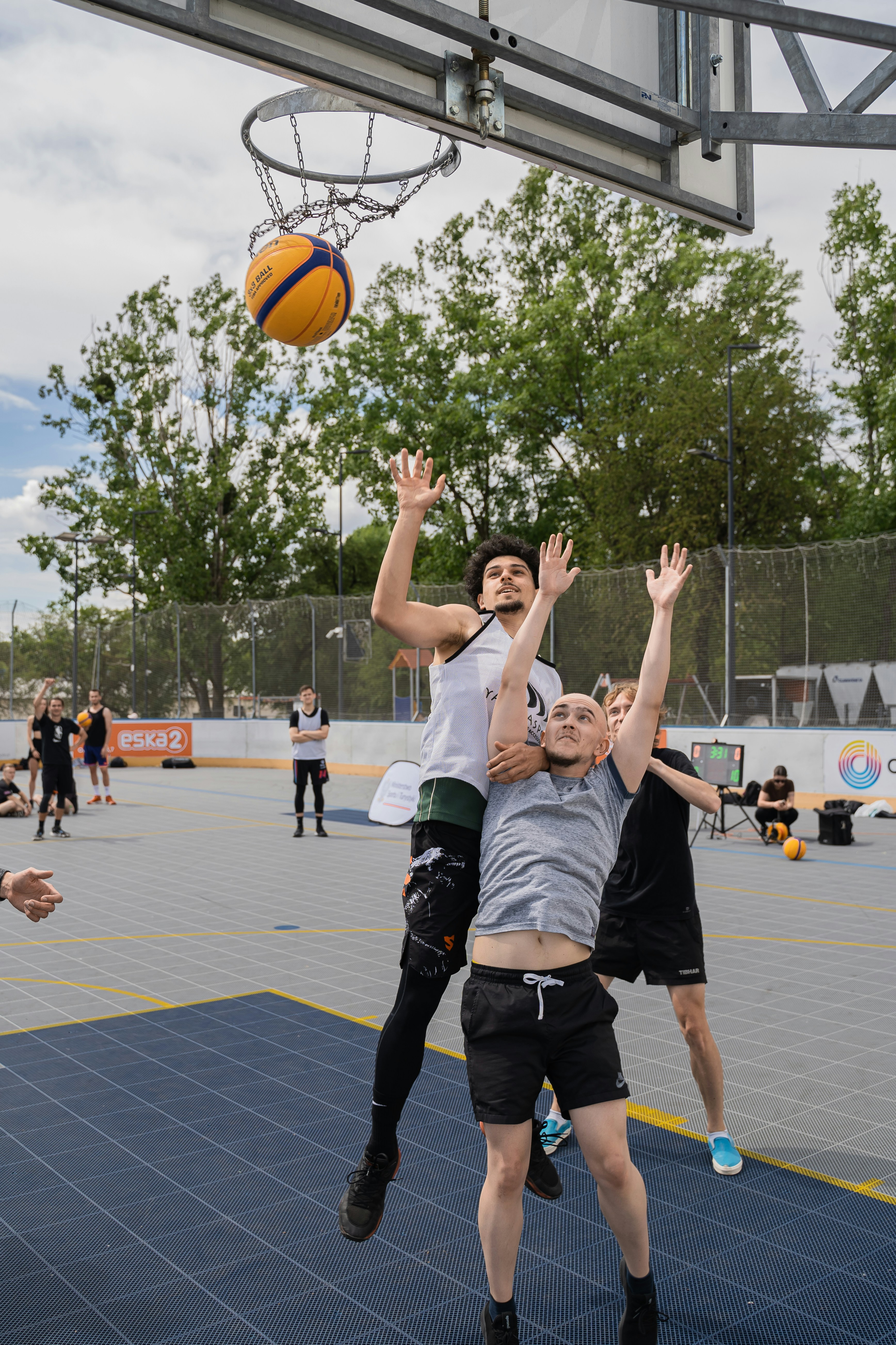 Basketball players competing to grab the rebound.