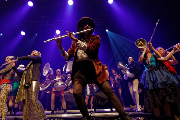 A band plays music on stage, illuminated by blue light