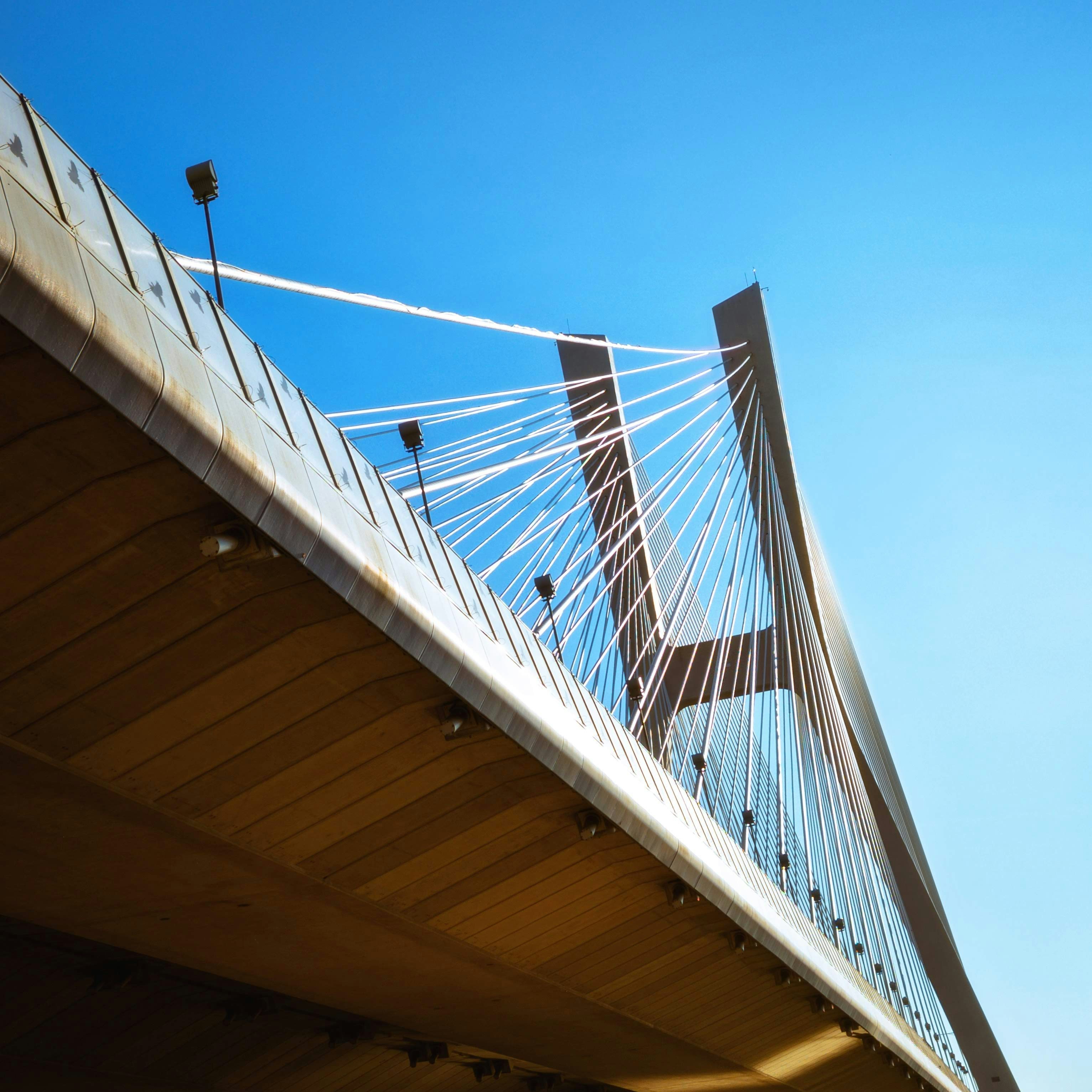 Bridge with cables against bright blue sky.