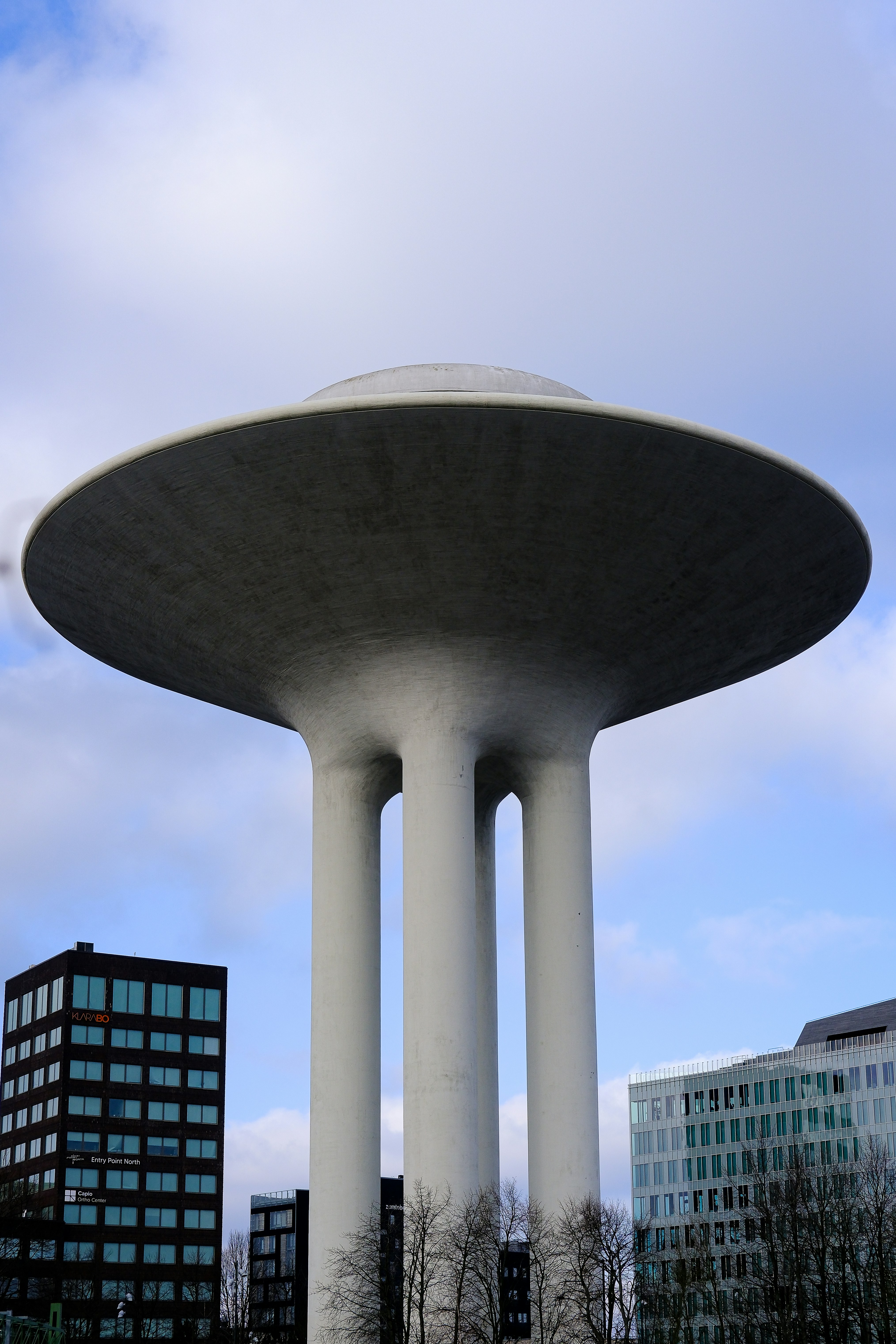 A modern water tower stands tall among buildings.