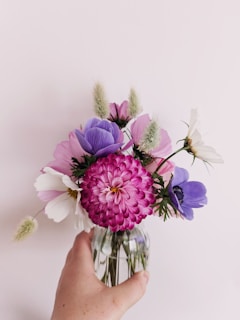 Vibrant flowers arranged in a small glass vase.