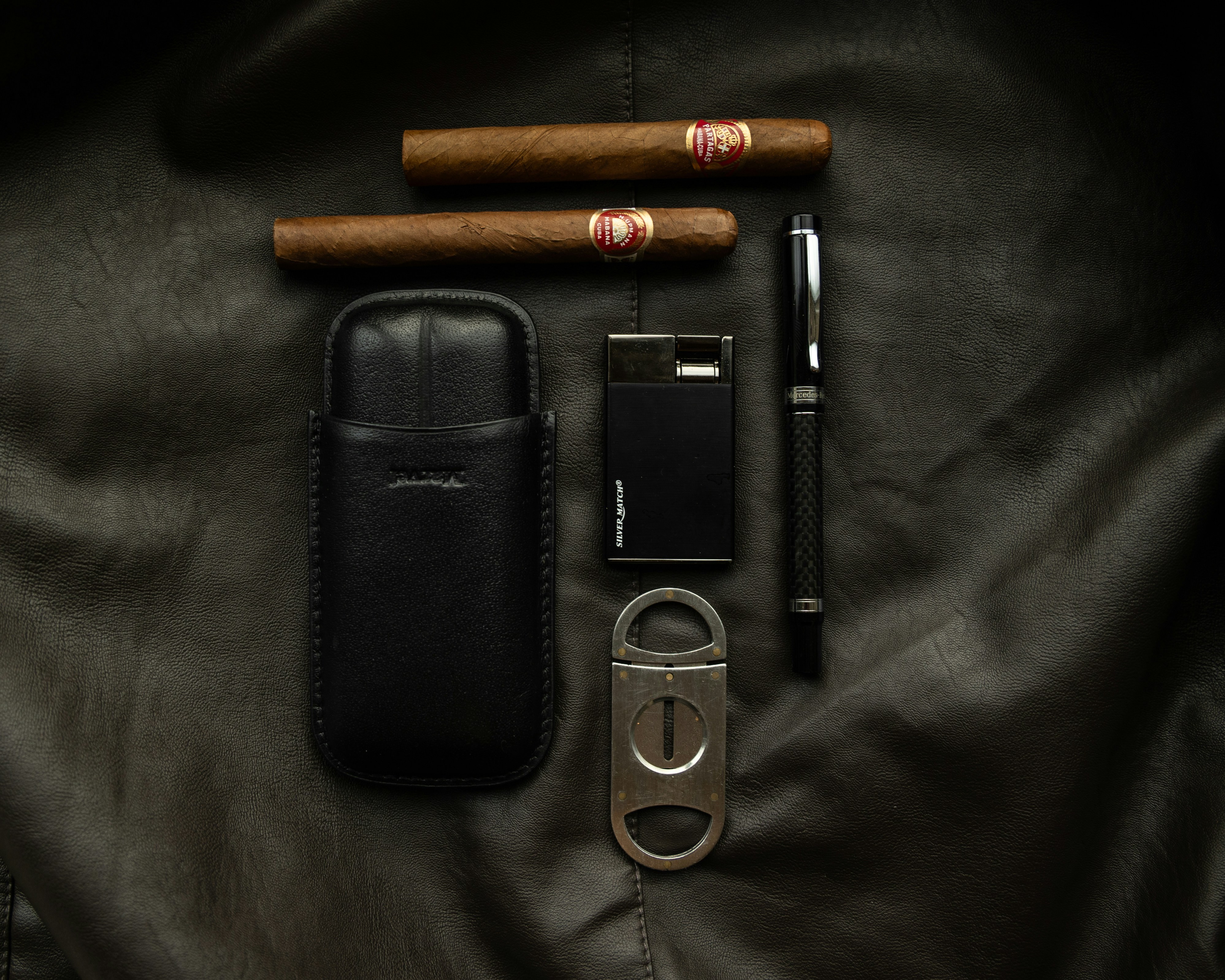 Cigars, lighter, cutter, pen, and case displayed.