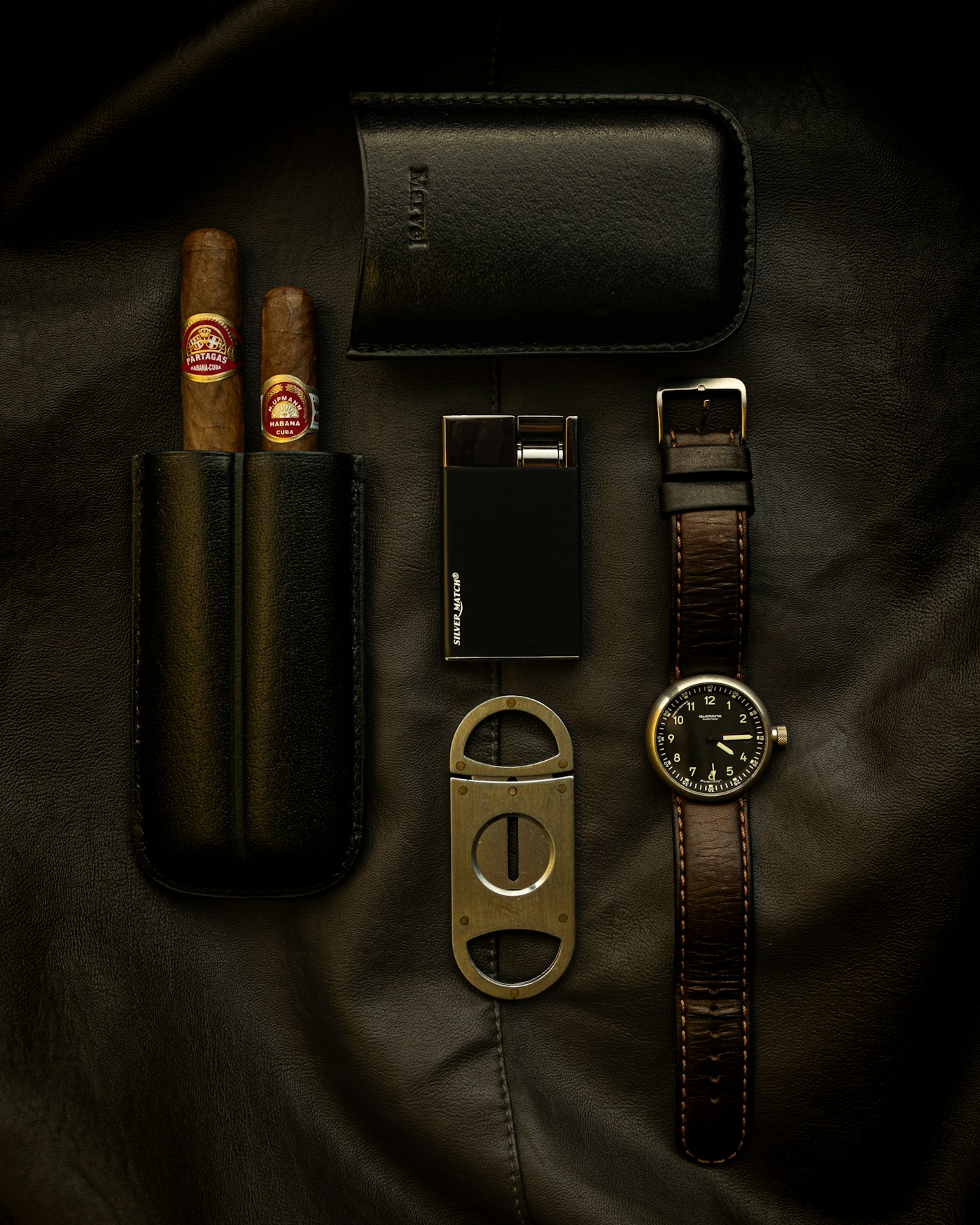 Cutter laid out with the cigar case and lighter on leather