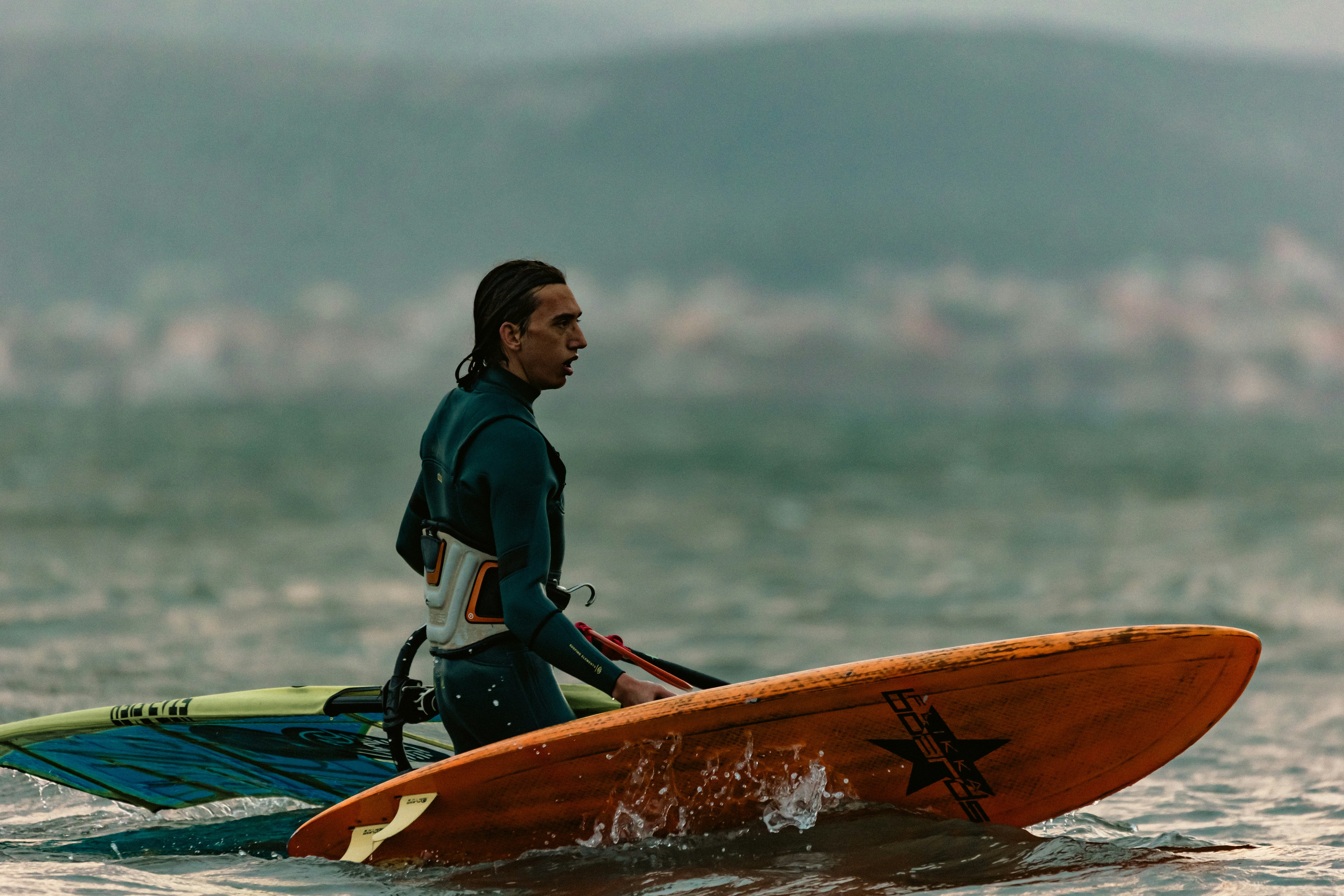 El surfista lleva su tabla en el océano.