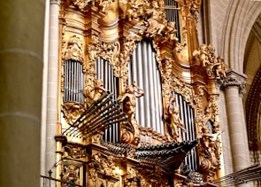 An ornate, golden pipe organ is depicted.