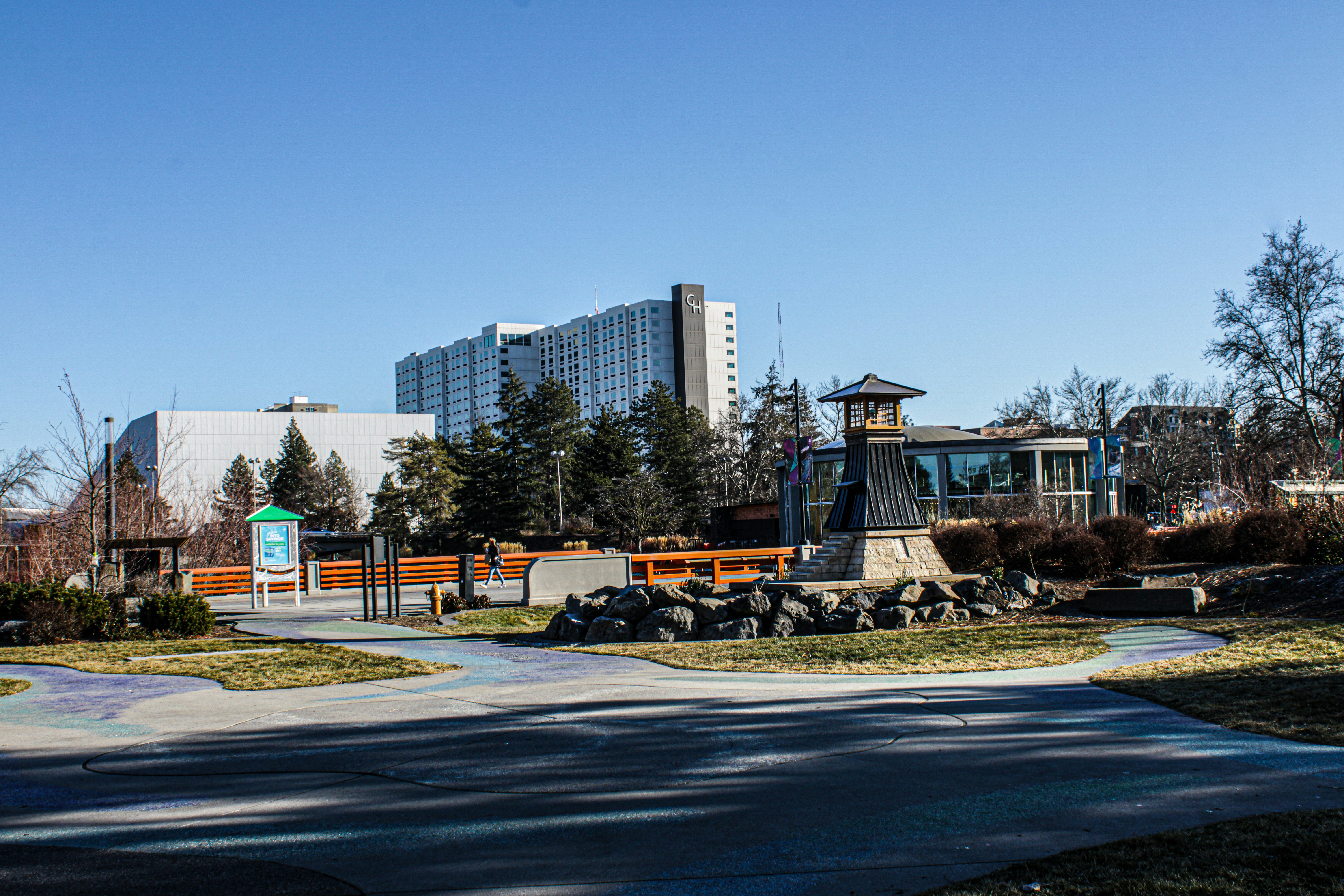 A park with buildings under a clear sky.