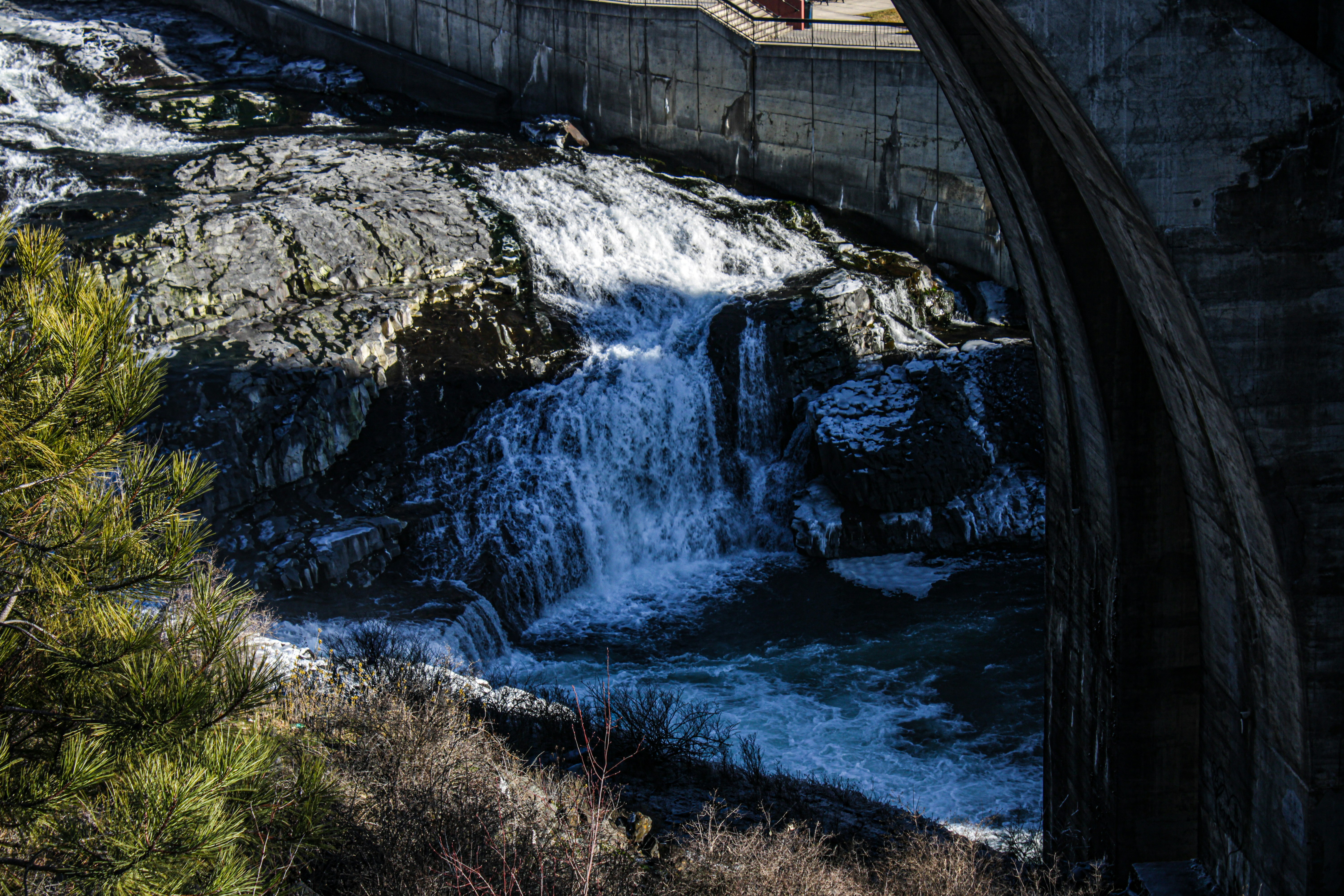 Water flows over a dam, creating a waterfall.