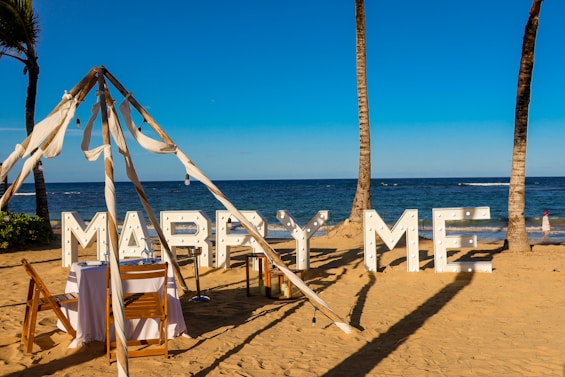 A romantic beach proposal with a "marry me" sign.