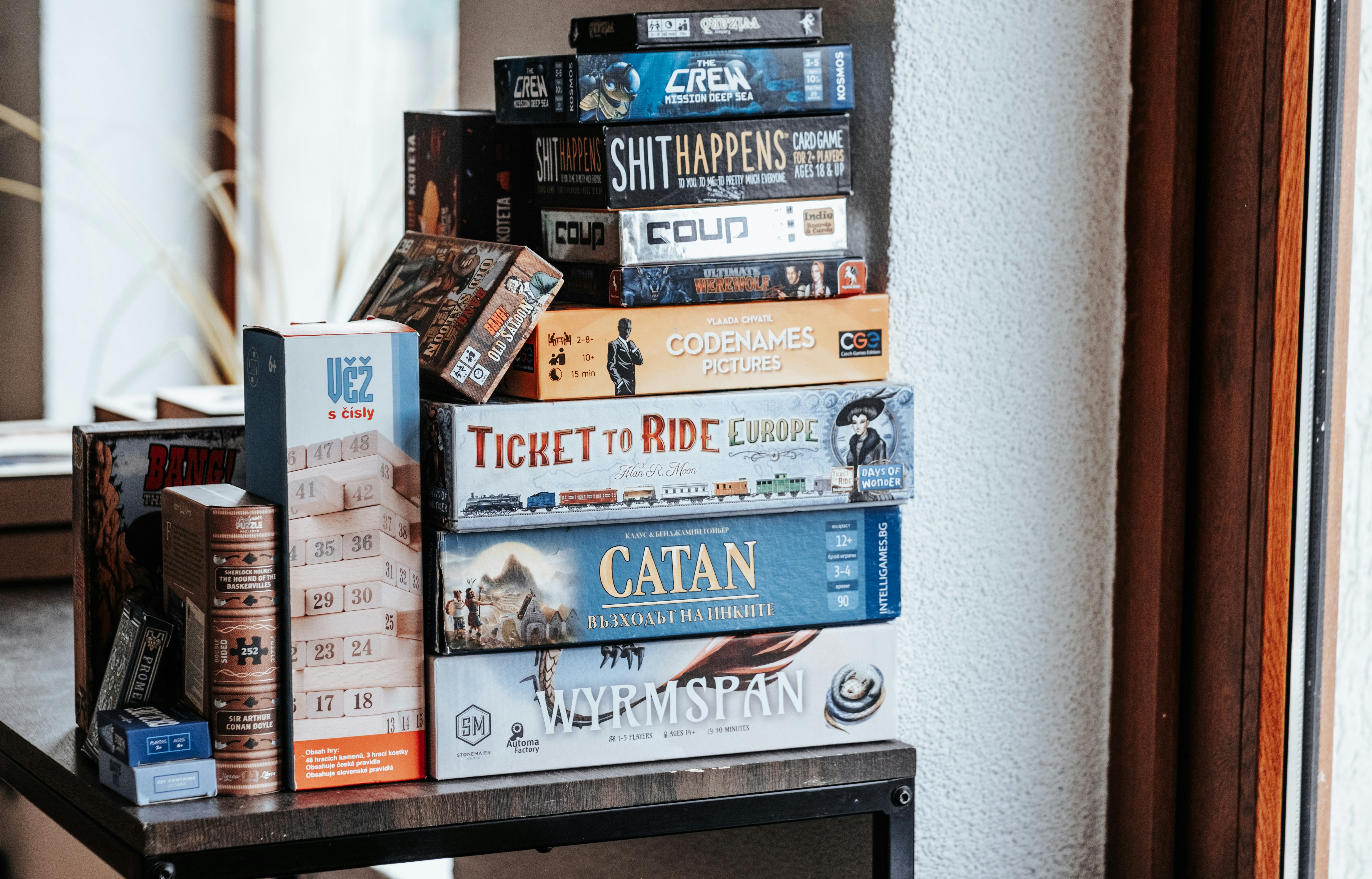 Board games are stacked on a shelf.