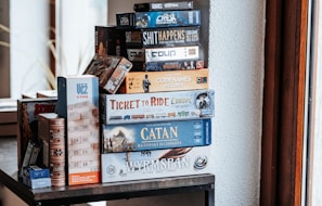 Board games are stacked on a shelf.
