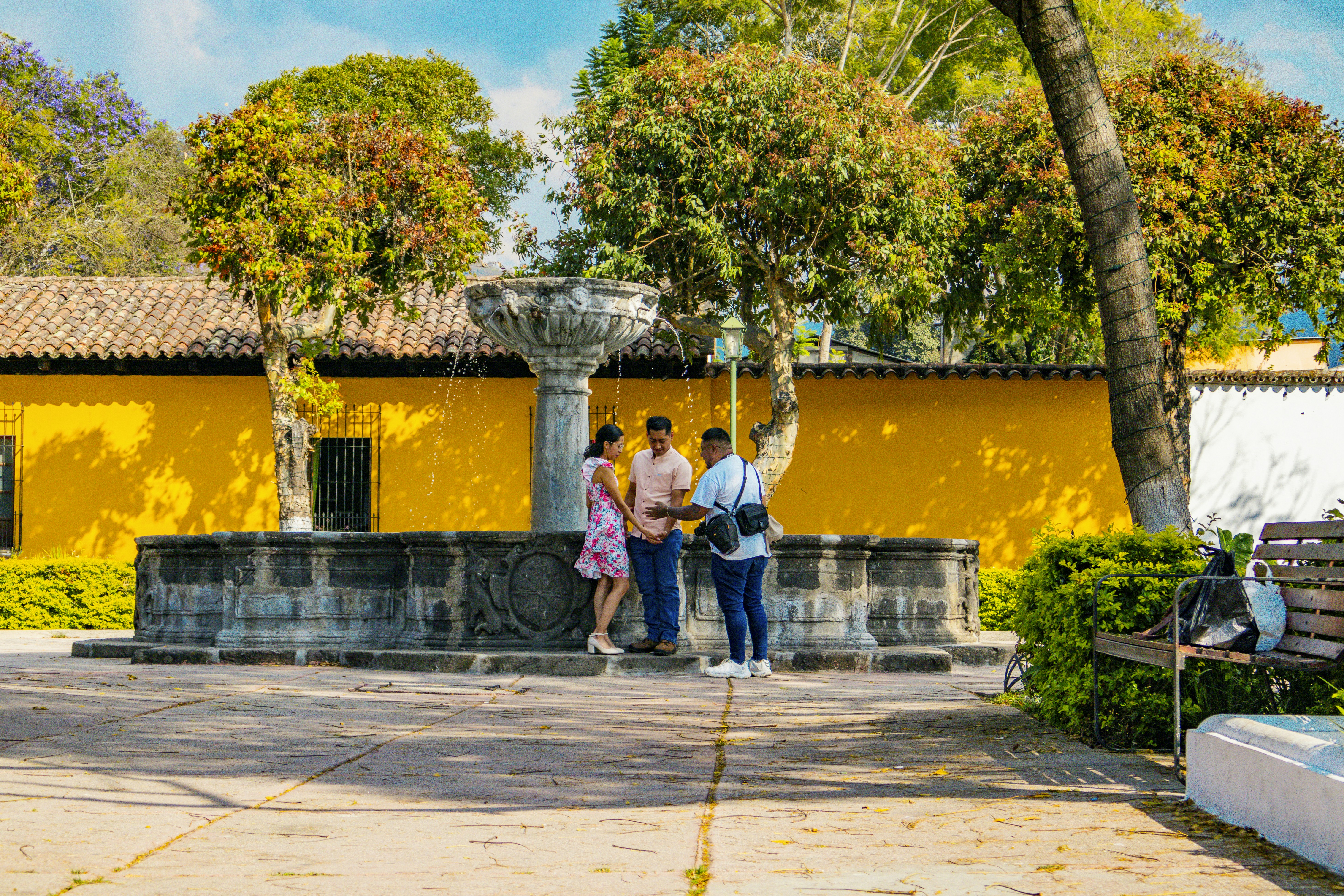 People are gathered around a beautiful fountain outdoors.