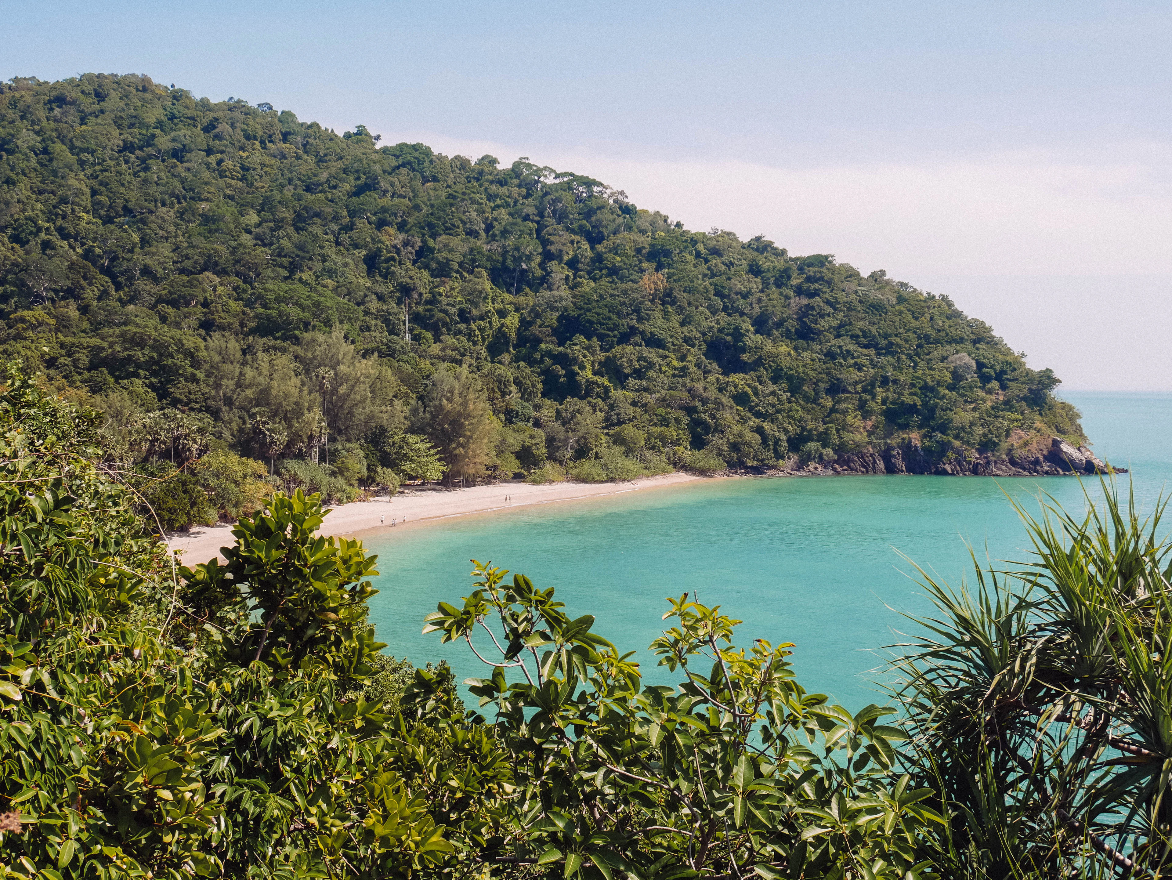A forested headland and turquoise water in Koh Lanta's national park