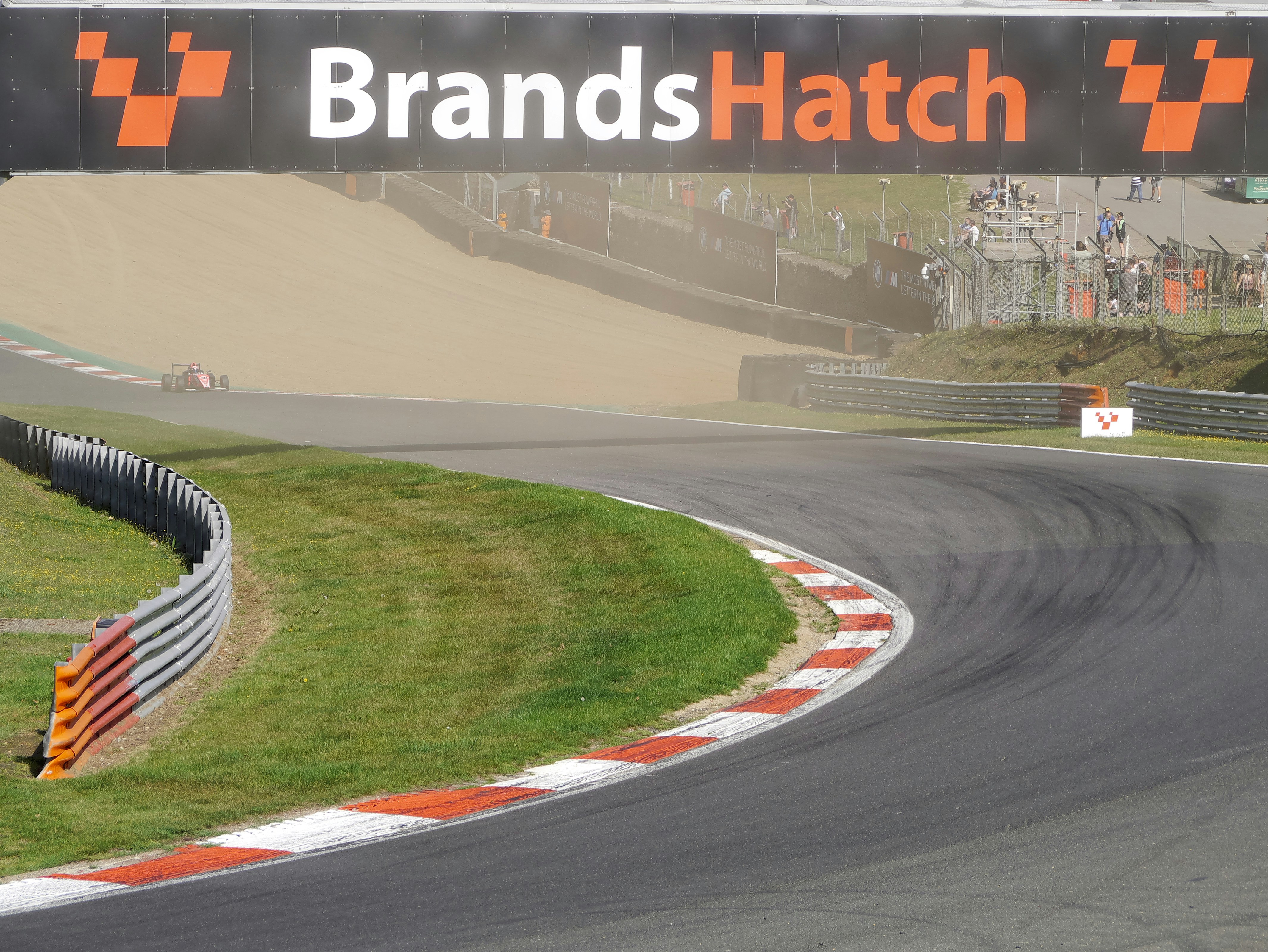 Race cars are on a track named brands hatch.