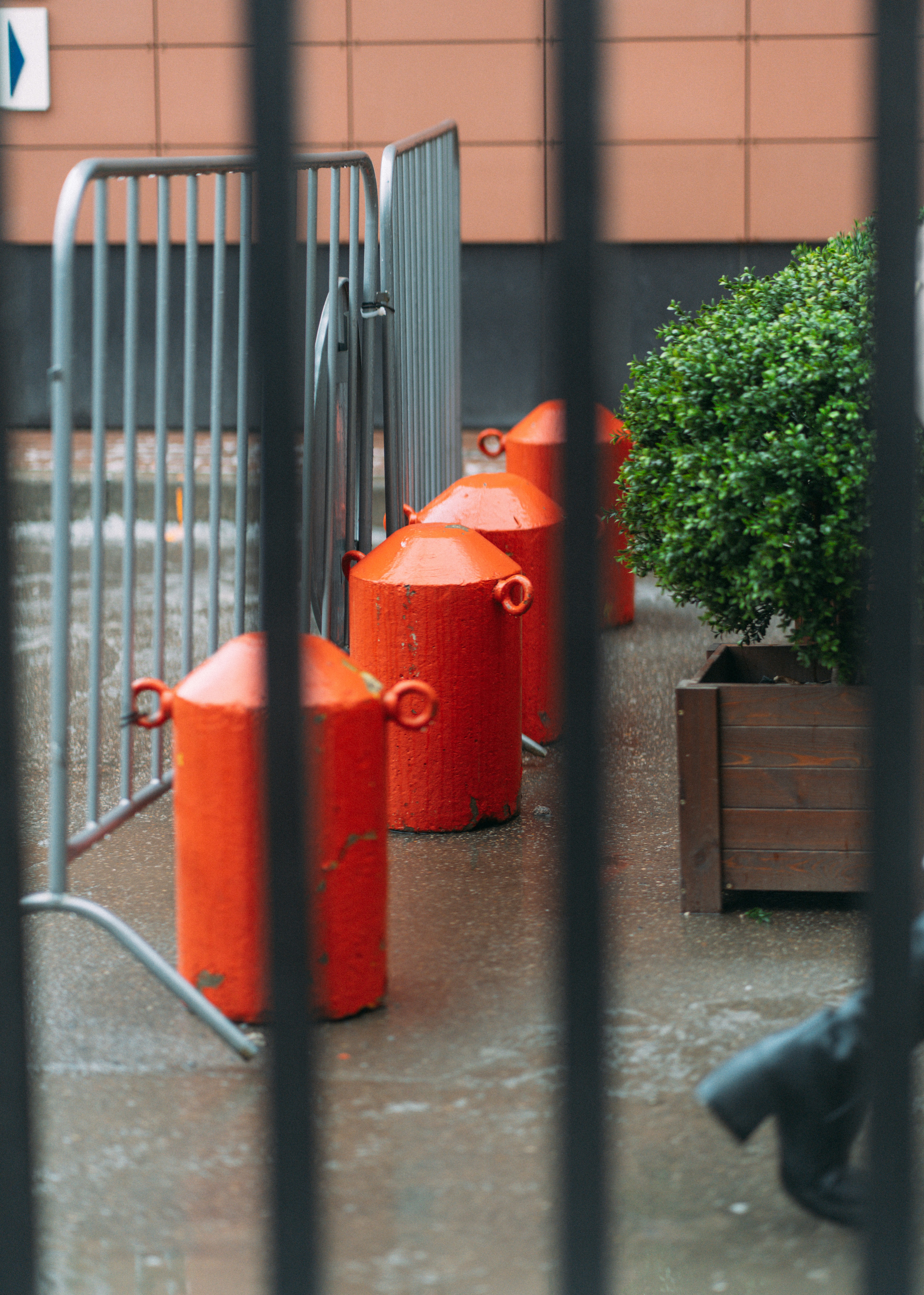 Red bollards and a fence obstruct the view.