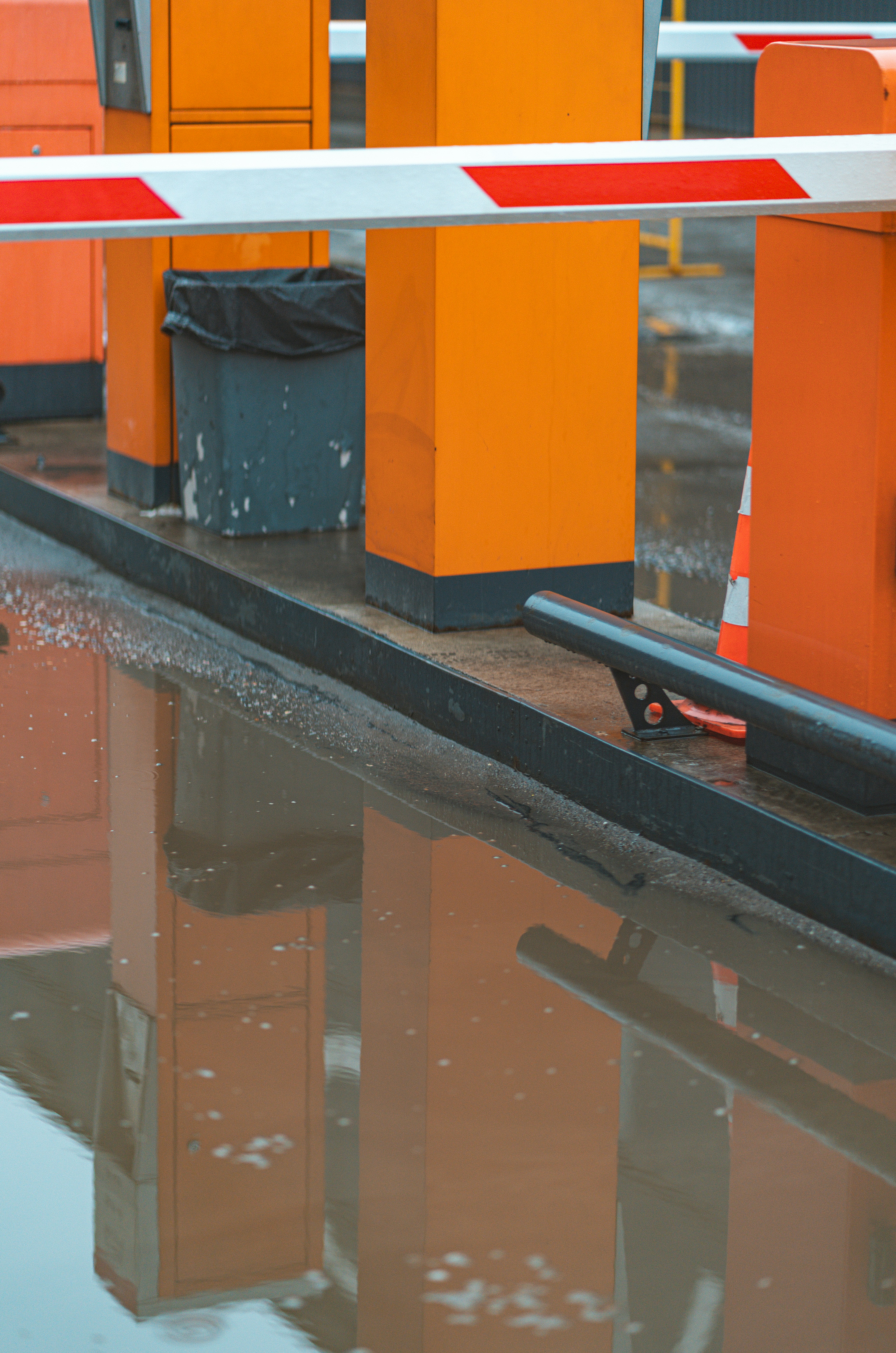 Parking lot barrier reflects in the water.