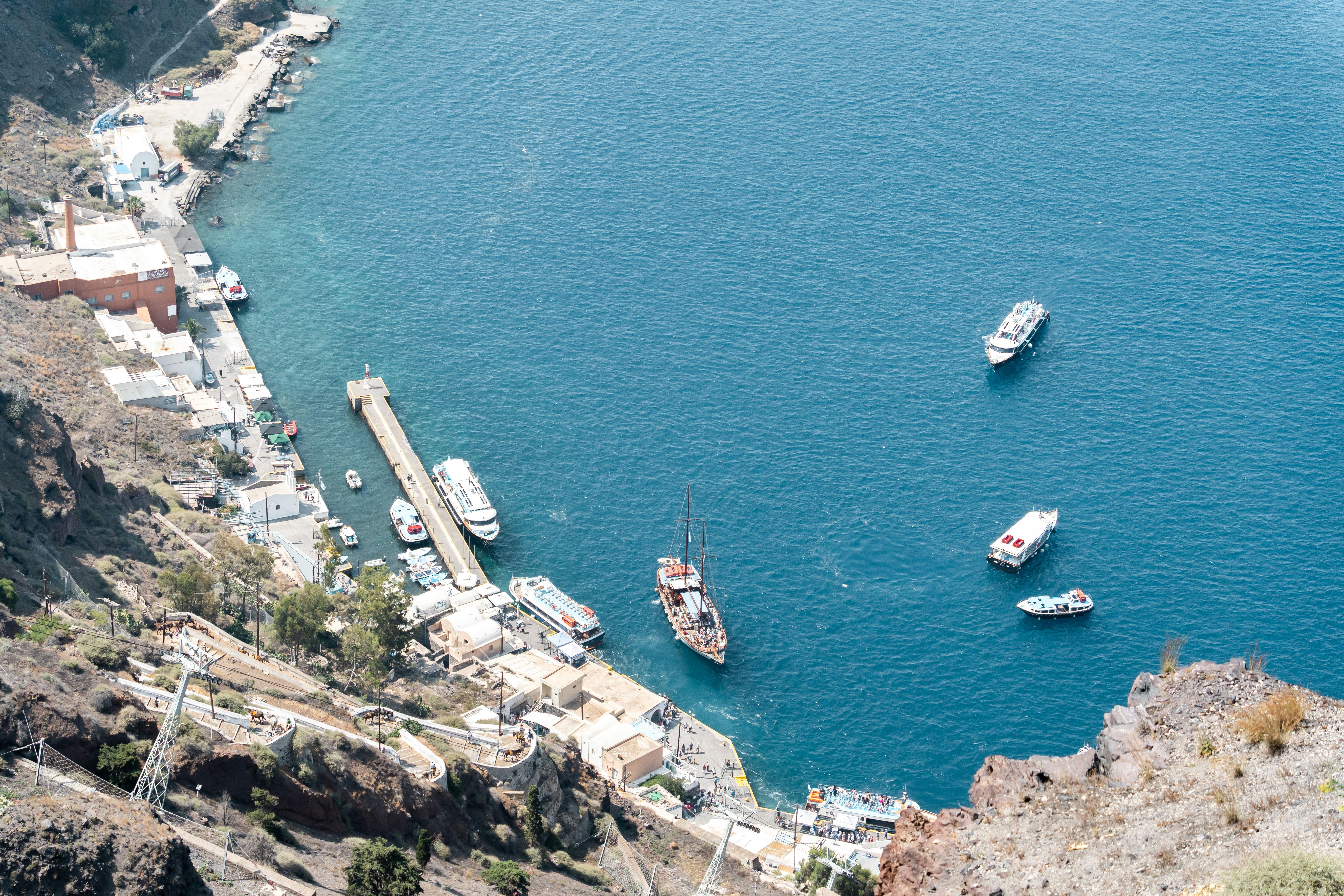Boats are docked along the shore of a sea.