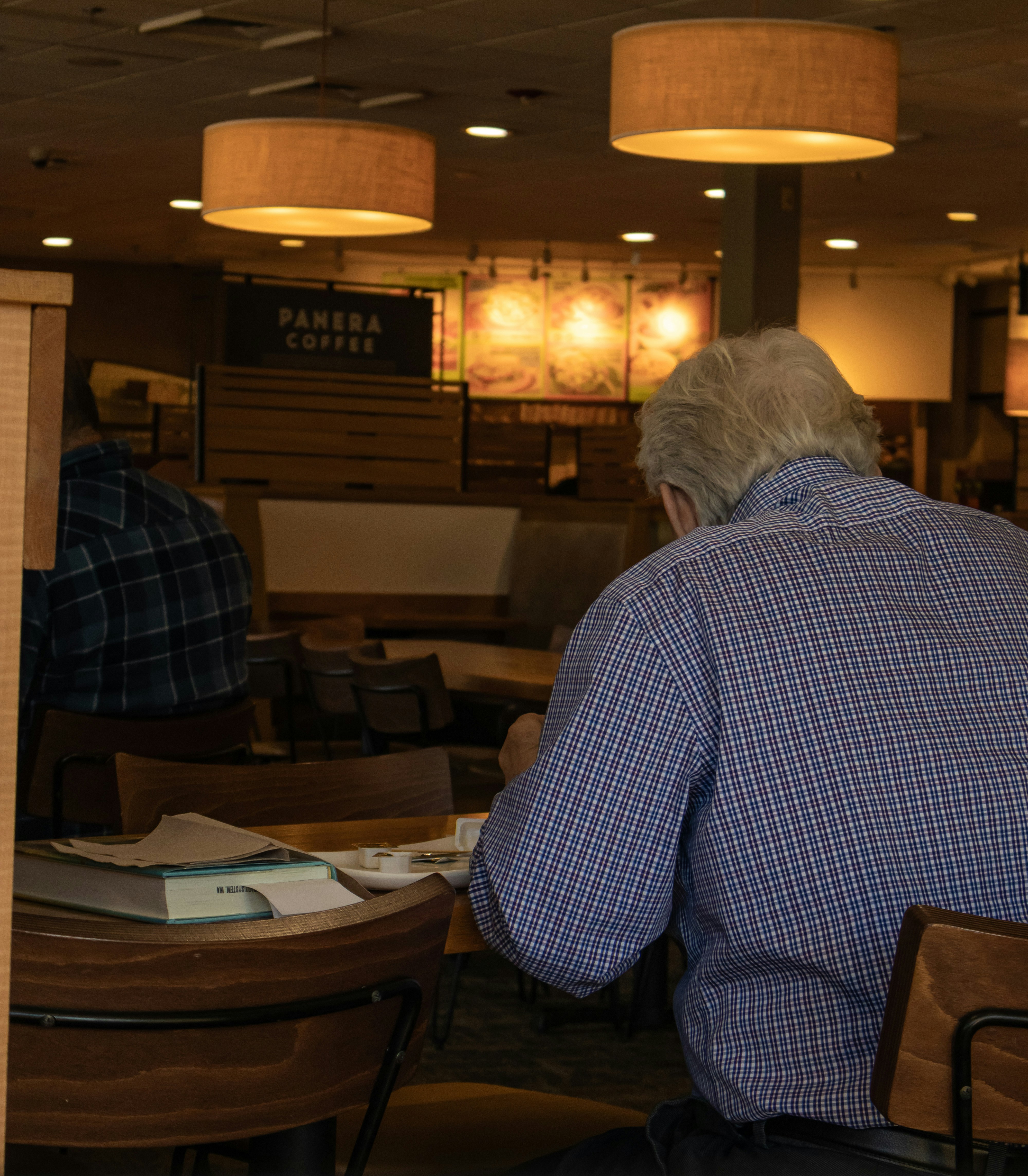 Man is working at a table in panera.