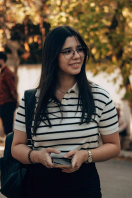 Smiling woman with glasses and a striped shirt.