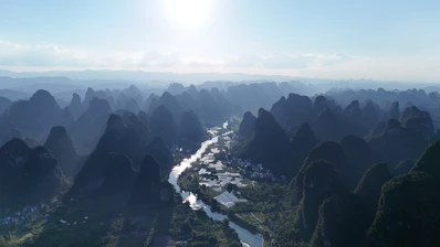Mountains surround a river in the countryside.