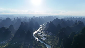 Mountains surround a river in the countryside.