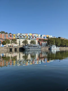 Colorful buildings reflect in calm water.