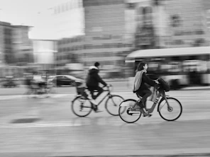 Bicyclists ride through a city street in motion.