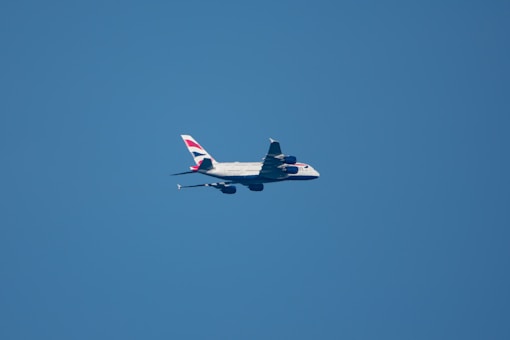 Airplane flies high in the clear blue sky.