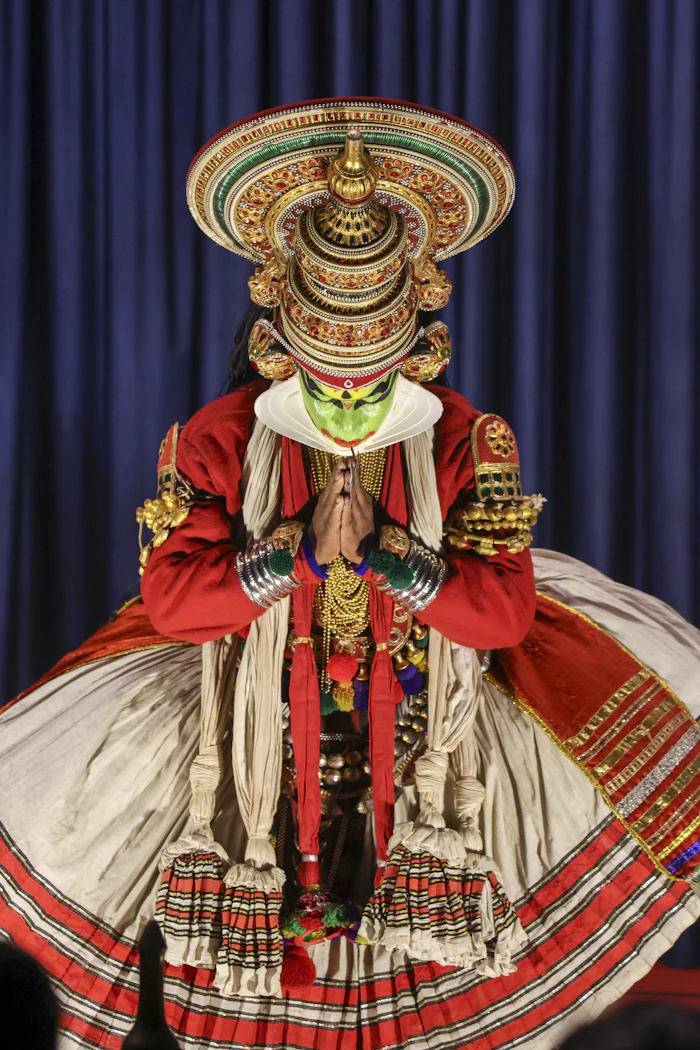 Kathakali artist in full costume and headdress with hands joined