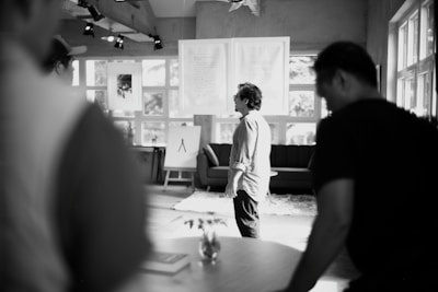 People gather indoors near artwork.