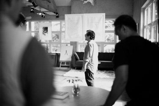 People gather indoors near artwork.