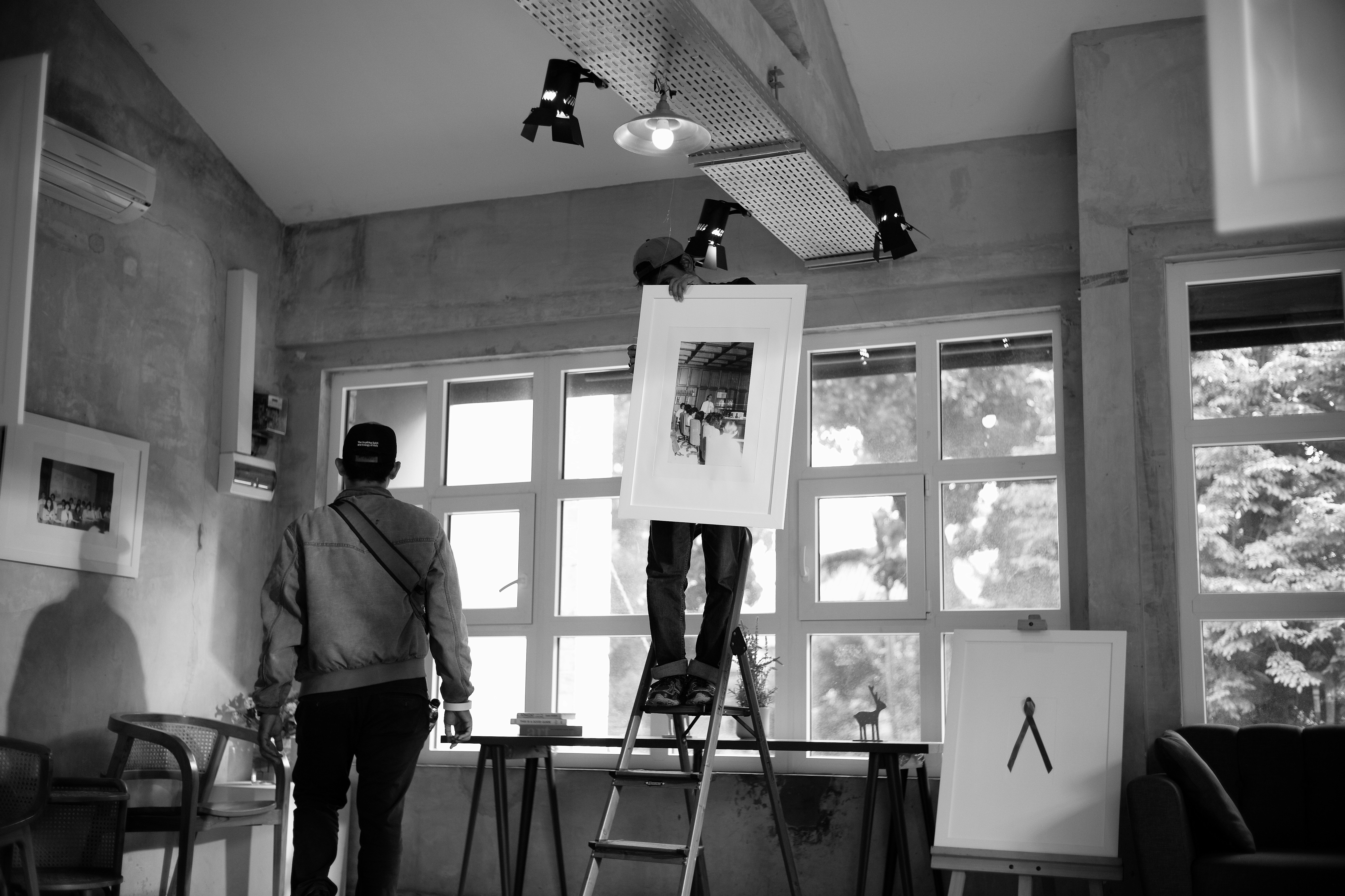 People hanging artwork in an art gallery