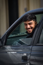 Smiling man in a car.