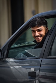 Smiling man in a car.