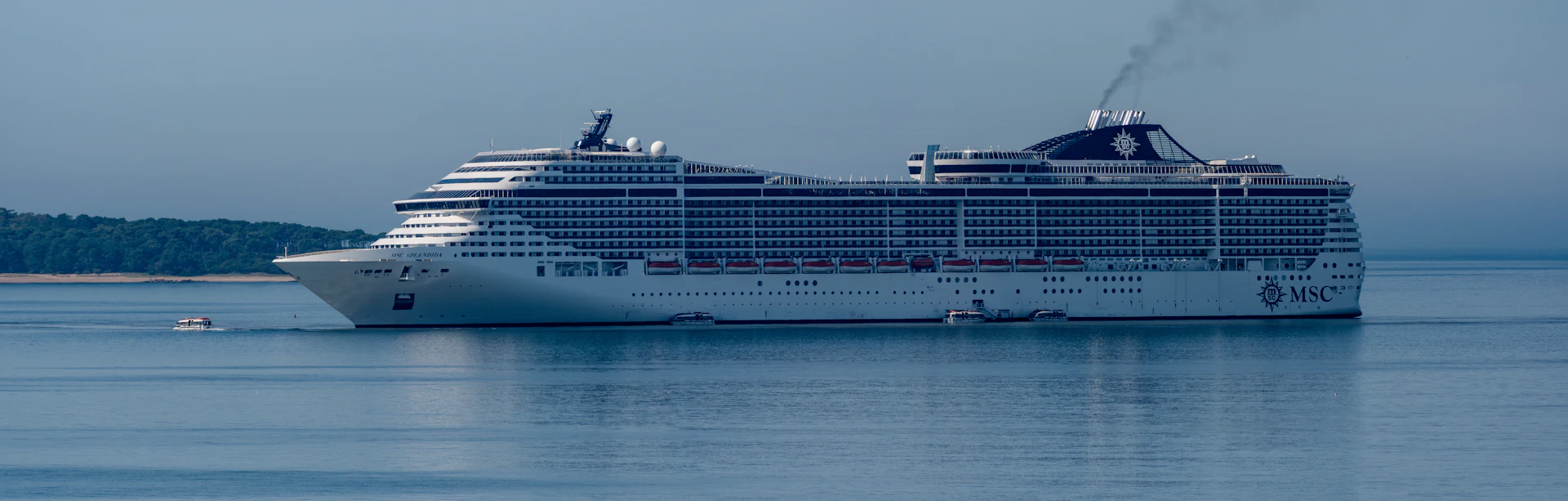 A large cruise ship sails on the calm sea