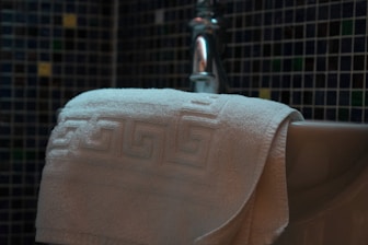 A towel hangs over a bathtub edge.