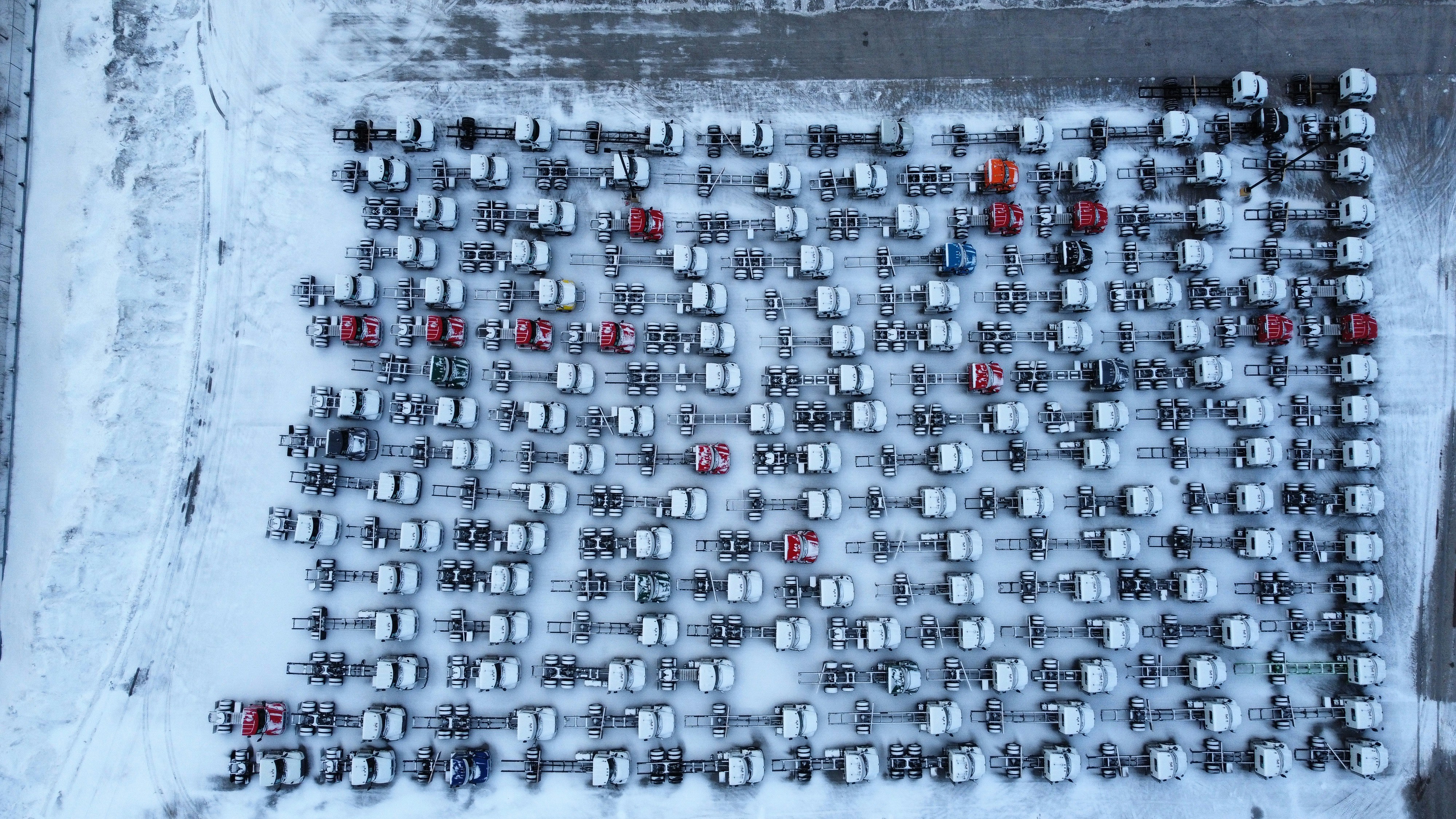 Cars are parked in the snowy lot.