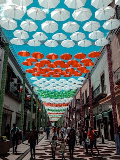Umbrellas adorn a pedestrian street with colorful canopies.