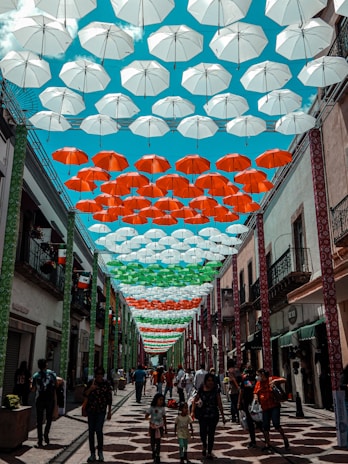 Umbrellas adorn a pedestrian street with colorful canopies.