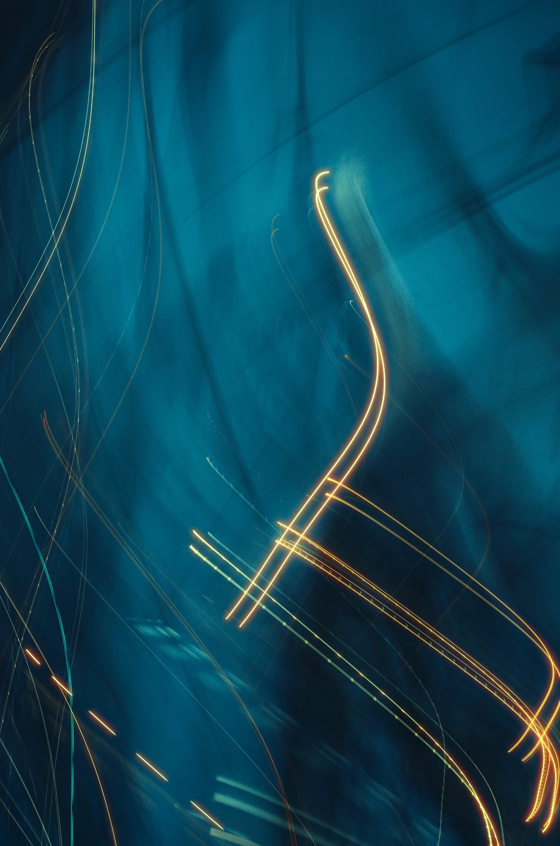 Abstract lights trail across a deep blue backdrop.