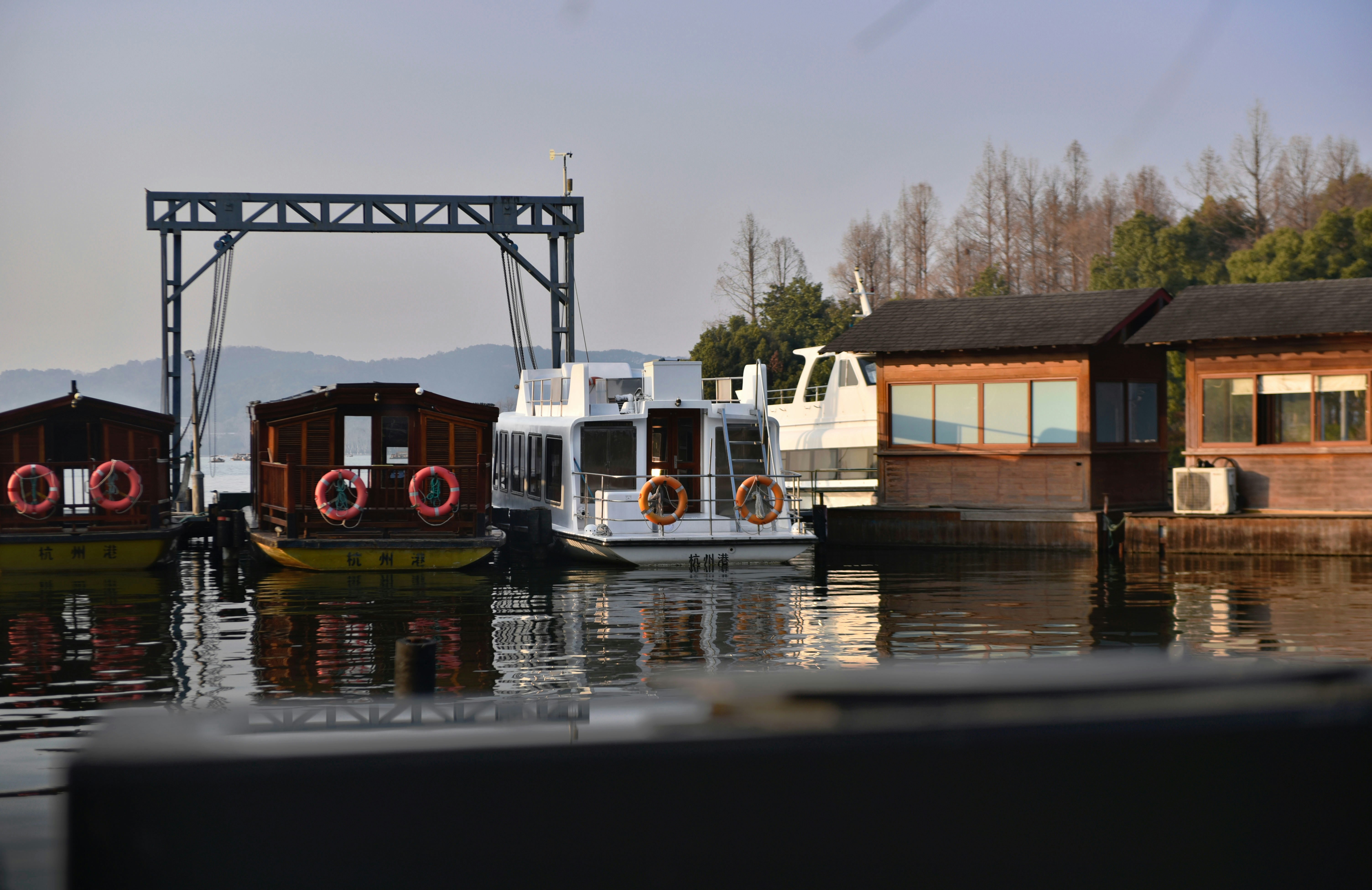 Boats are docked at a pier on calm water.