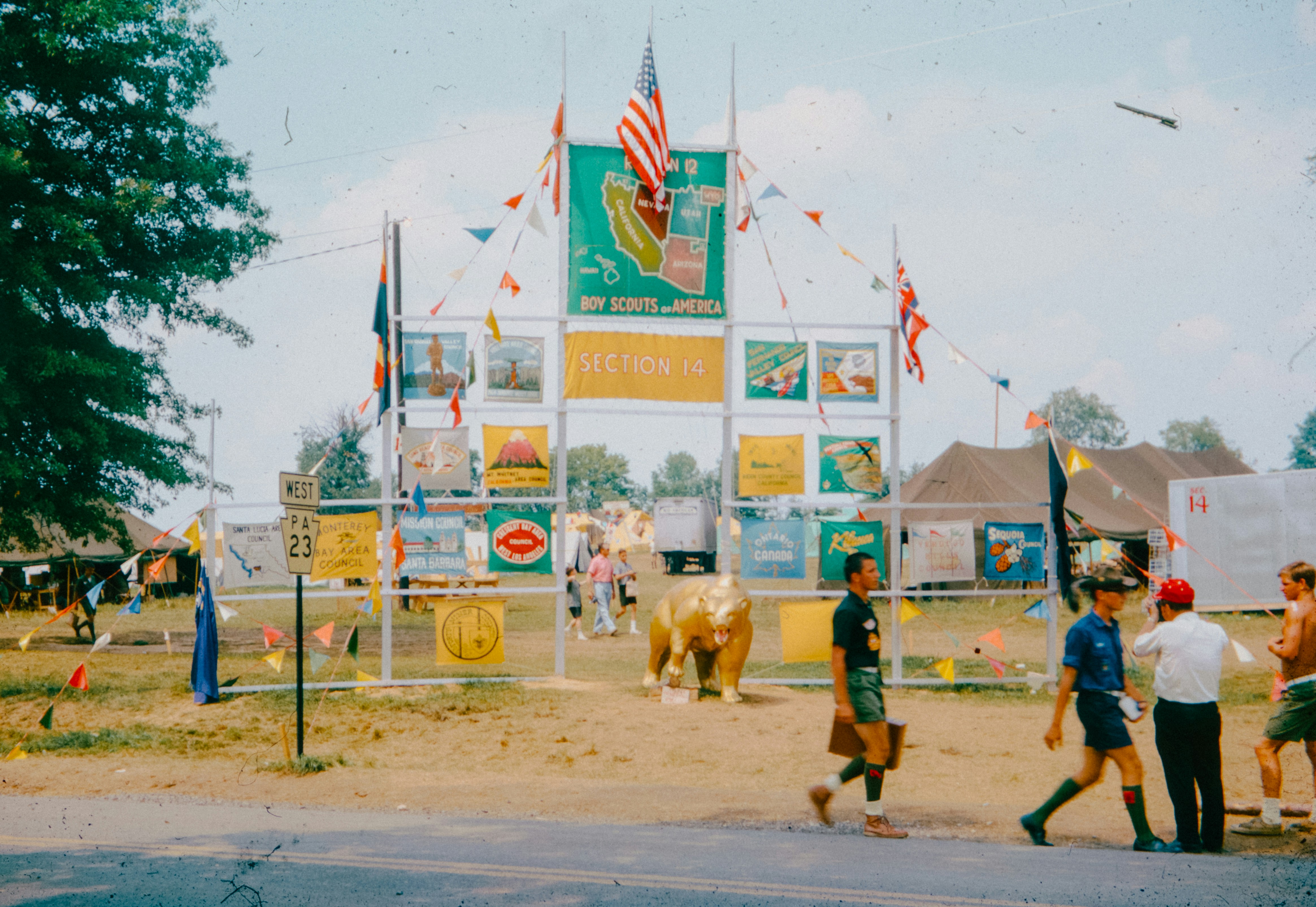 Boy scouts walk through a decorated entrance gate.
