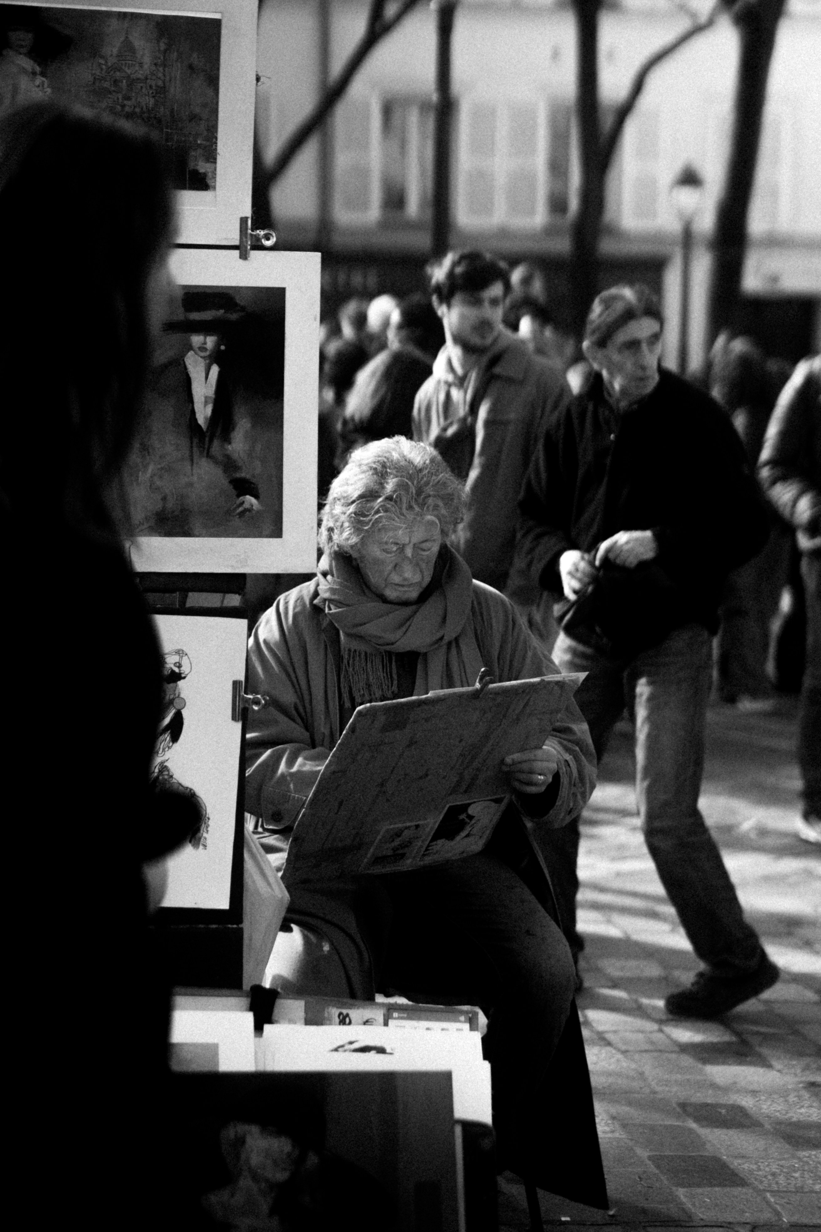 Kunstner maler på en travl byplads.