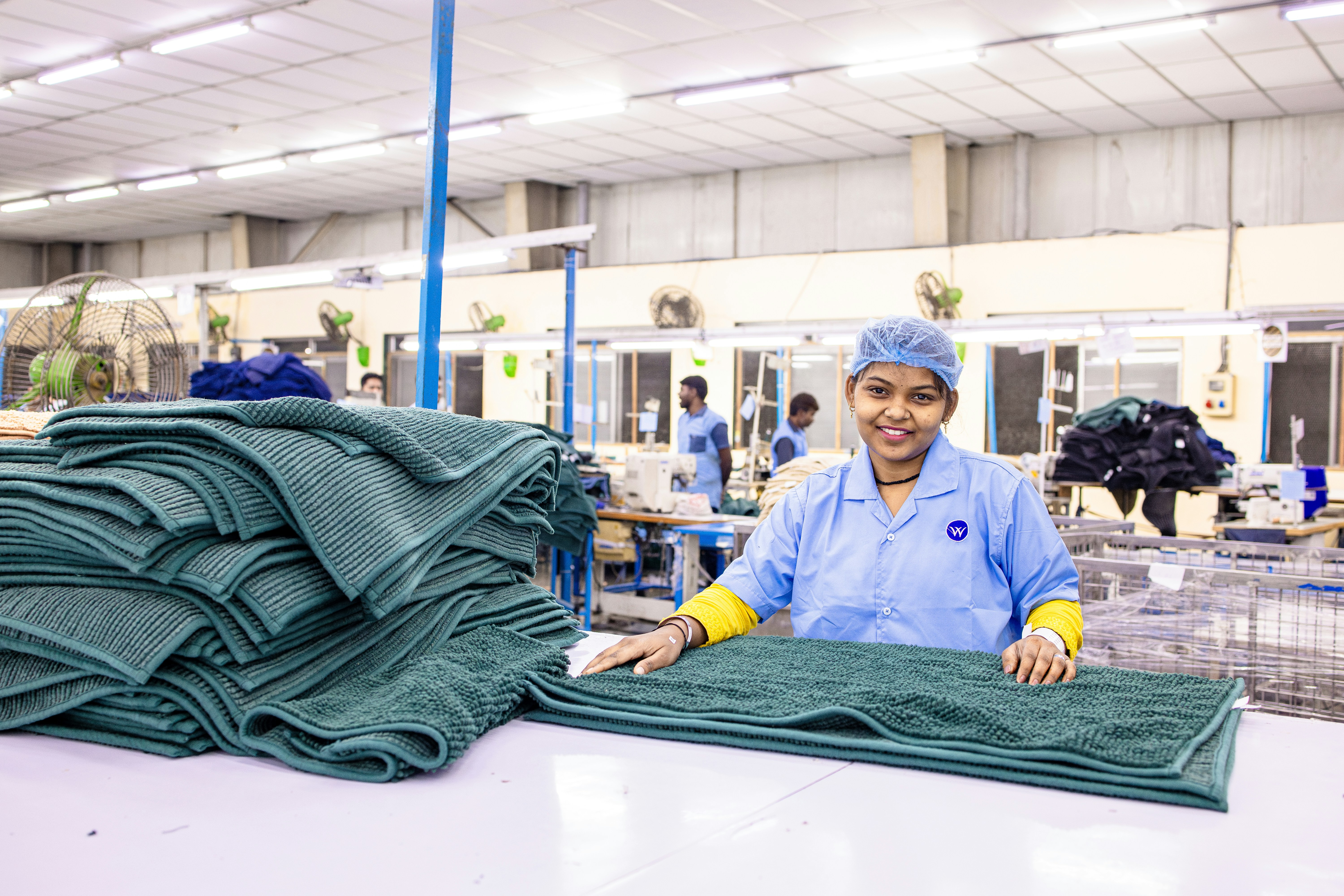 A worker sorts towels in a textile factory.