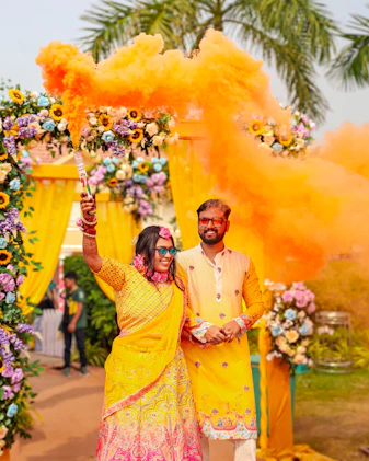 Couple celebrates with vibrant orange smoke during their event.