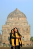 Mother and daughter smile in front of a monument.