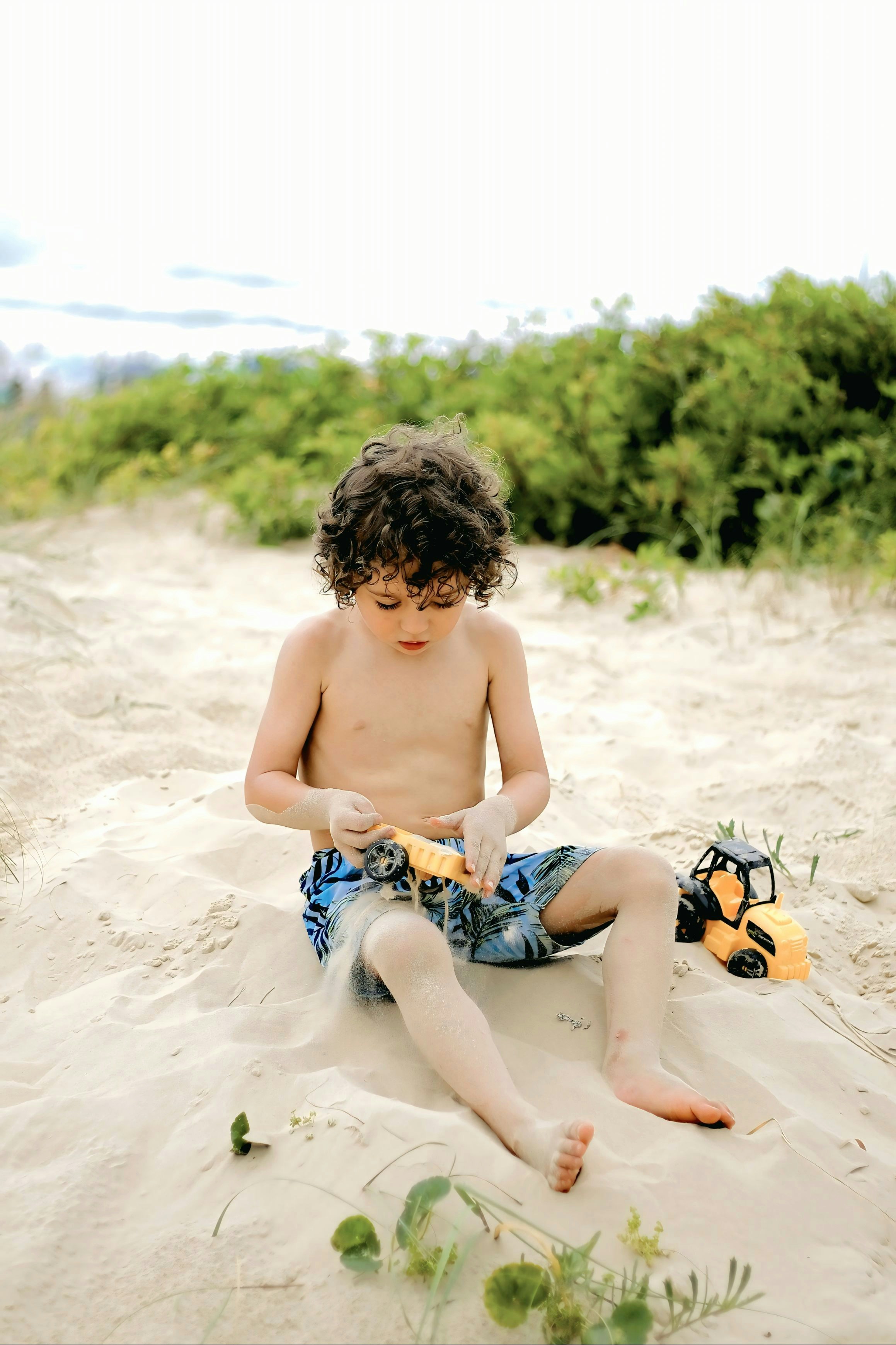 Child playing in the sand by the sea