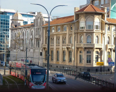 A tram travels along a street by old buildings.