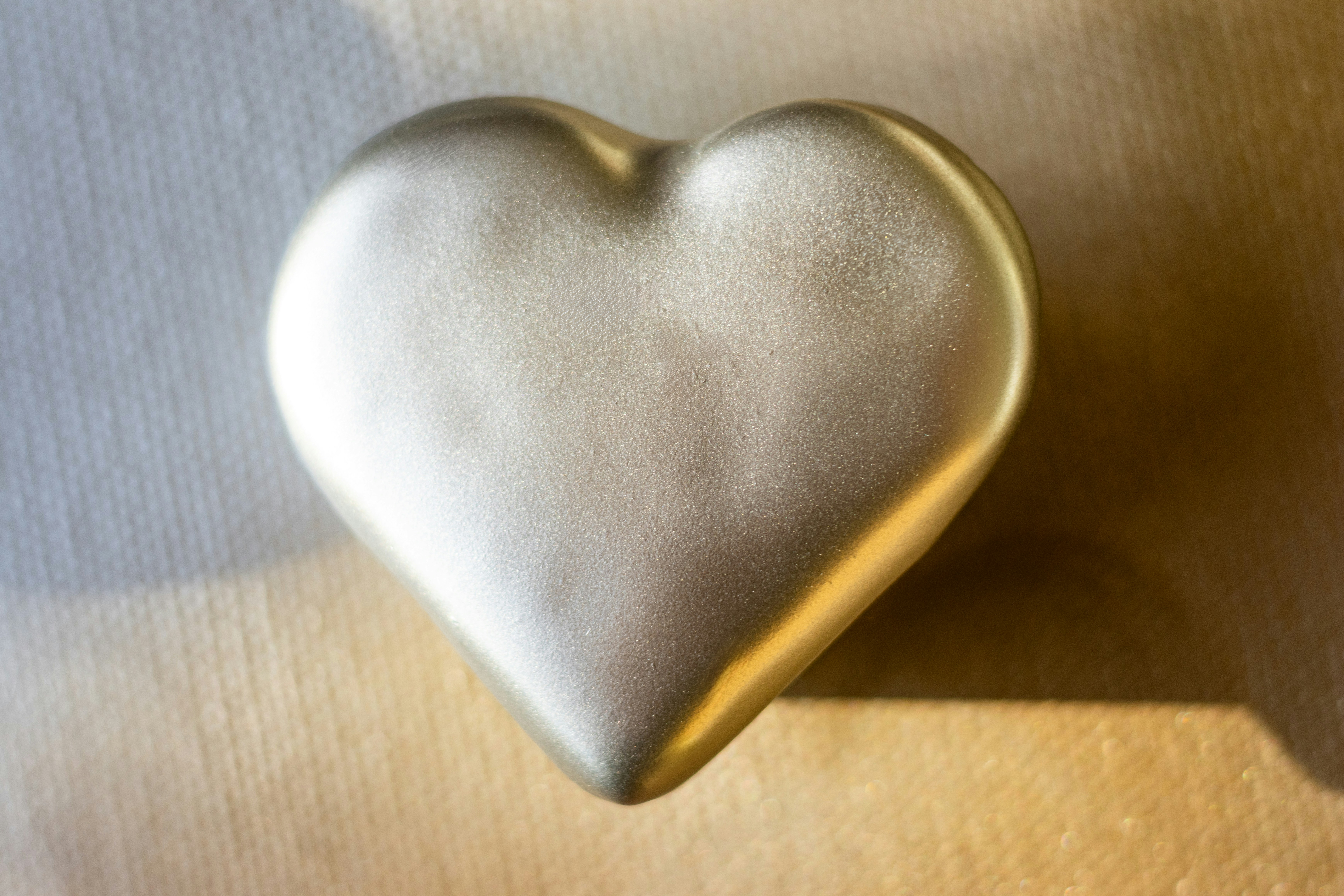 A shiny, golden heart resting on a surface.