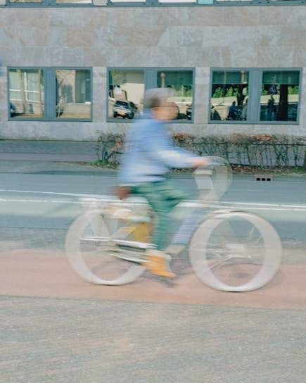 A blurry person rides a bicycle.