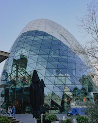 A unique, glass-paneled building stands tall.
